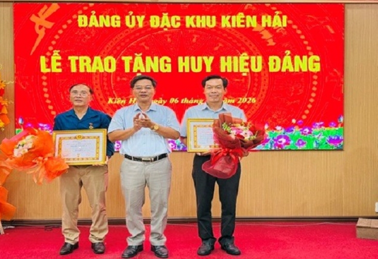 Quang cảnh: Đồng chí Nguyễn Quốc Tuấn, Bí thư Đảng ủy đặc khu, trao tặng Huy huyeeju Đảng cho các đồng chí 30 năm tuổi Đảng.
